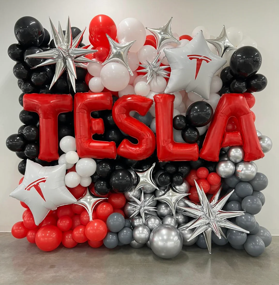 Tesla-themed balloon wall with marquee letters and silver star accents